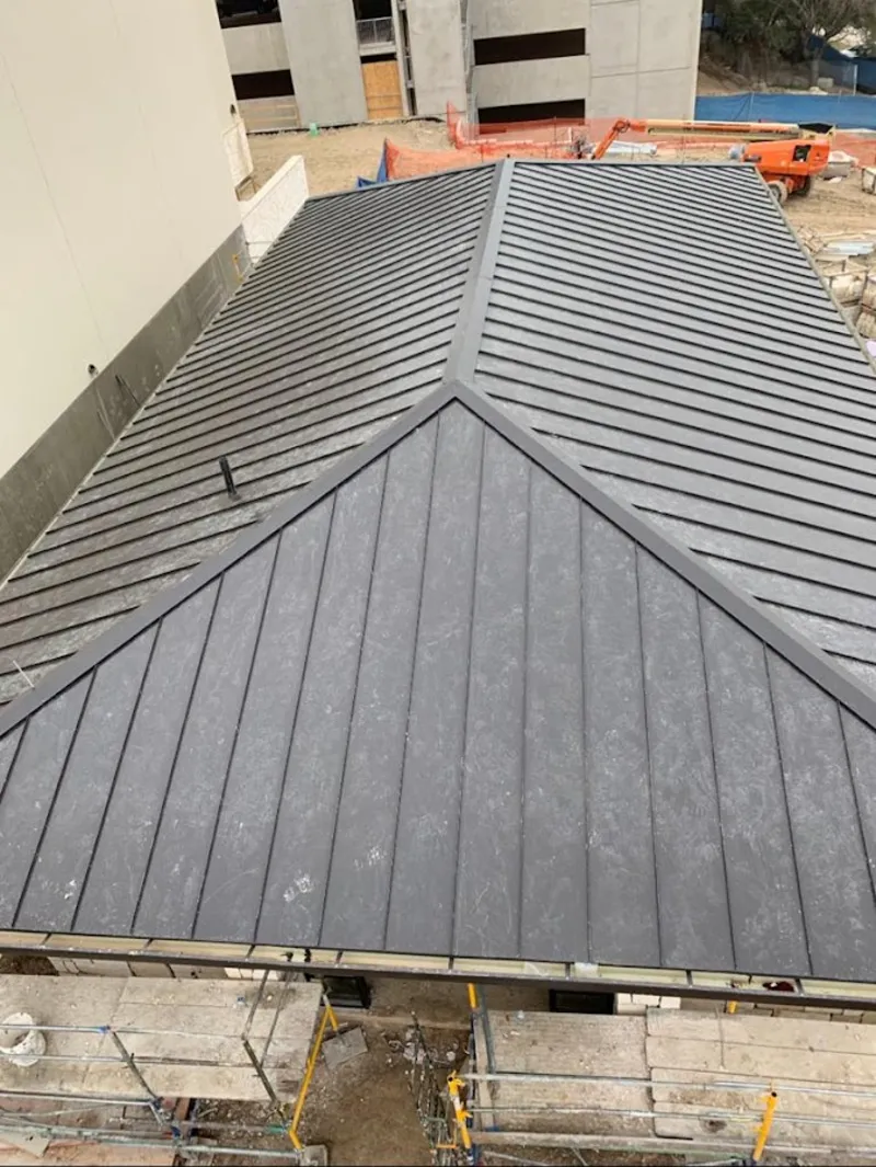 Commercial metal roof construction with crane equipment in Hickory Creek