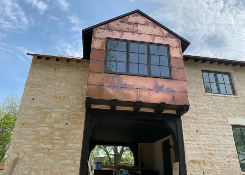 Copper metal panel facade on a stone building for Roof Repair in Hickory Creek